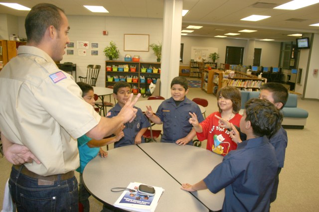 Scoutmaster Luis Ledesma leads members of Troop 1136 in reciting the Scout pledge.