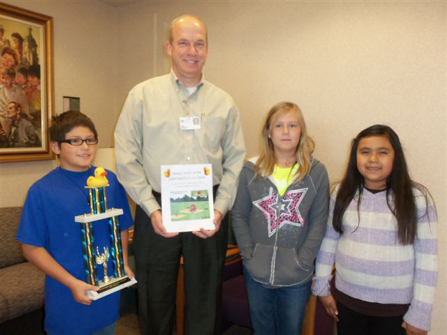 Woodbury students present John Hughes, CEO of Marshalltown Medical & Surgical Center, with the Duck Dash First Place traveling trophy.  The duck representing MMSC placed first in the Woodbury Duck Dash – Corporate division held on Tuesday, Oct. 8.  MMSC provided sponsorship for the fundraising effort for new playground equipment. 