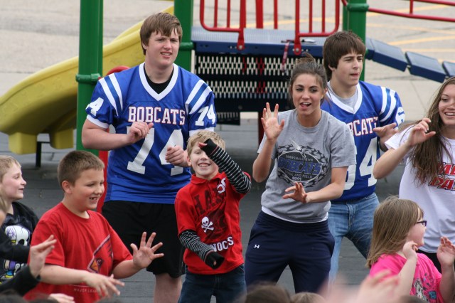 MHS students lead Hoglan Elementary in performing the UNI Interlude Dance.